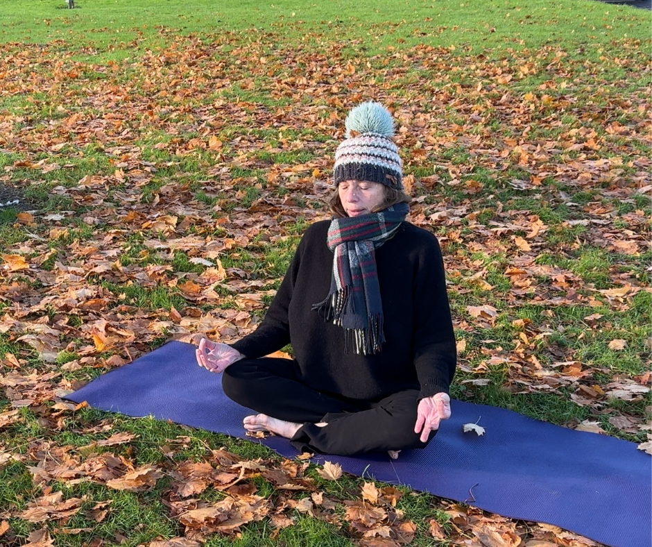 yogi meditating outside surrounded by Autumn leaves. An example of how to start your day